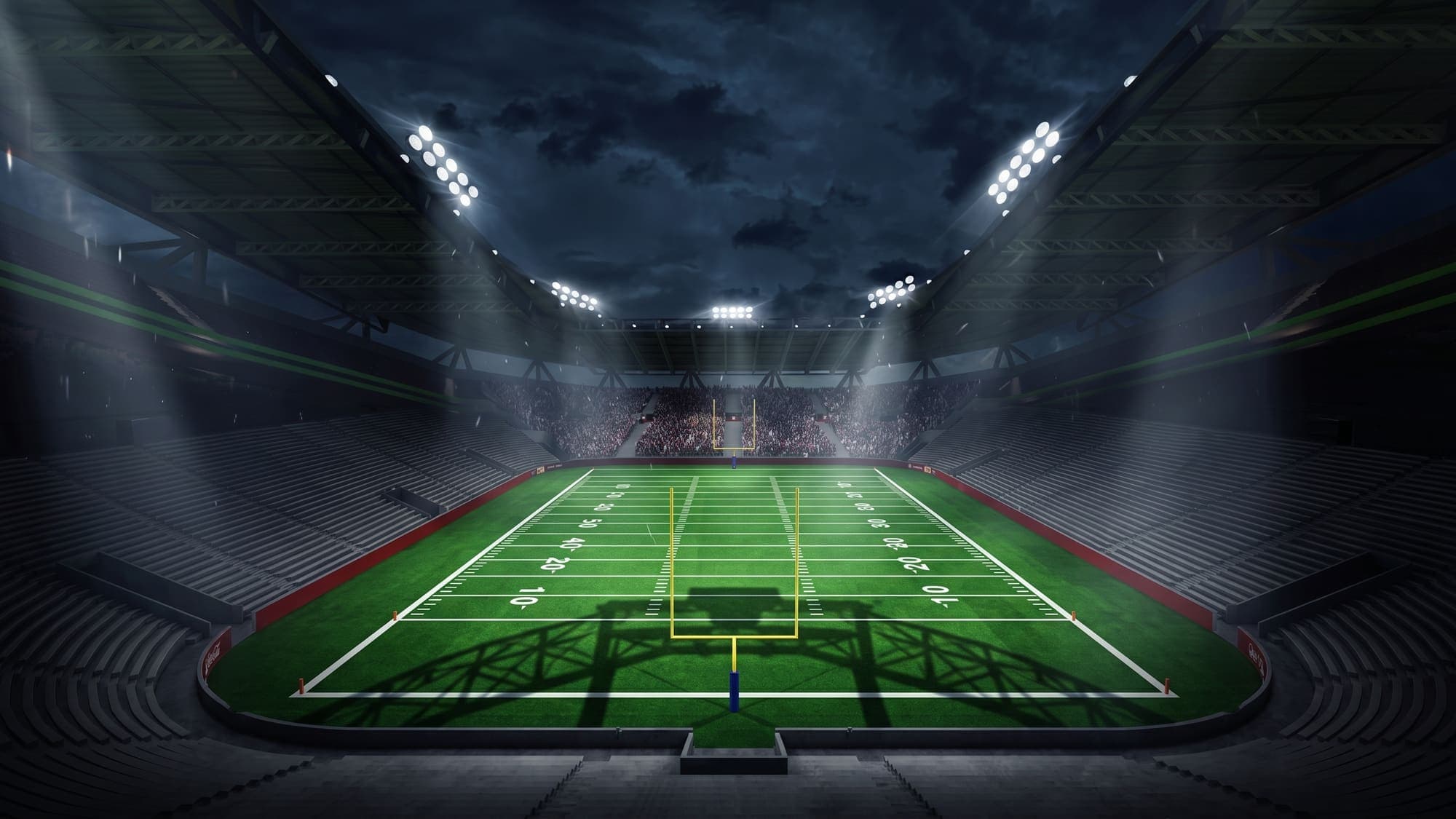 Uno stadio di football americano illuminato di notte, ripreso dalla end zone